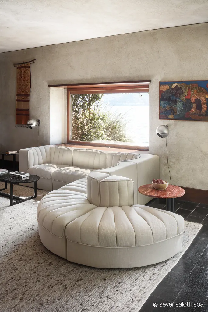 Composizione 9000 Arflex color avorio con isola curva in un soggiorno con finestra sul verde