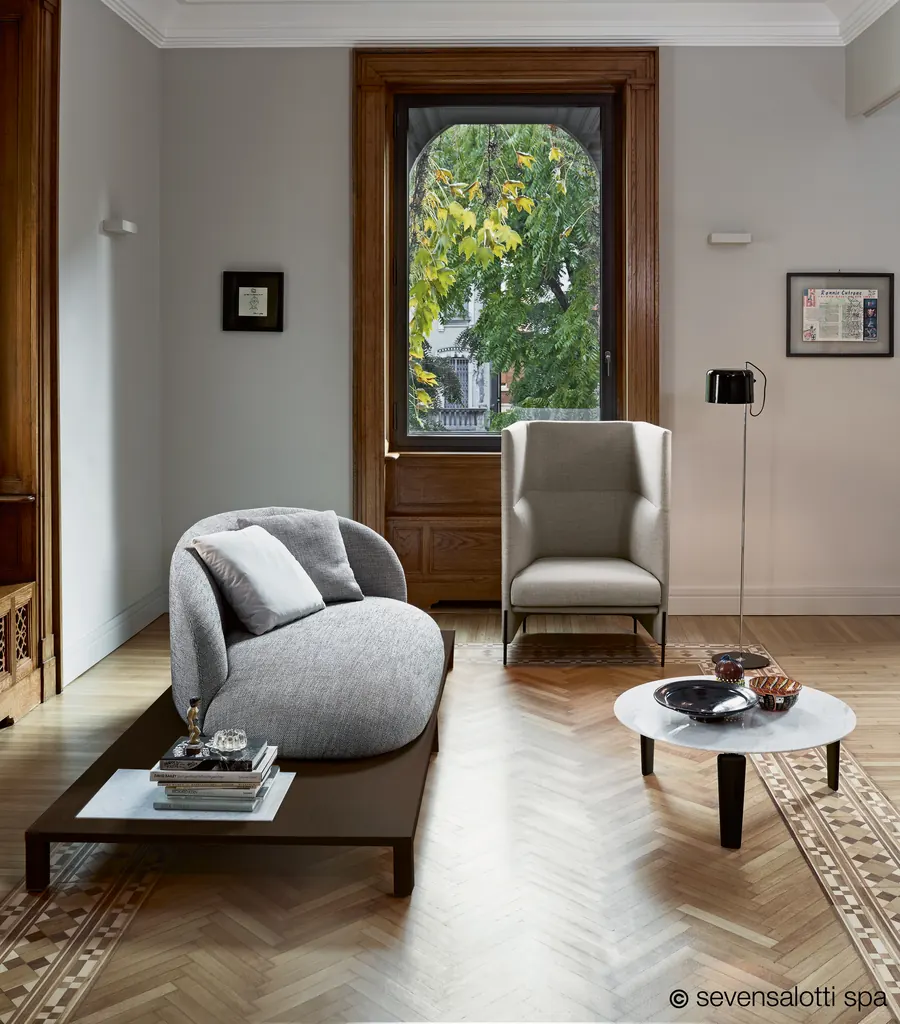 Poltrona Algon Arflex beige a schienale alto in un salone con parquet a spina di pesce