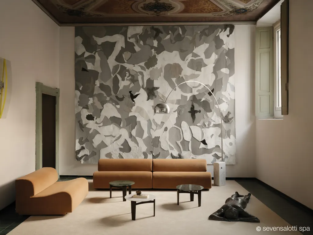 Two camel Arflex Bobo sofas in a room with a frescoed ceiling and a large grey tapestry