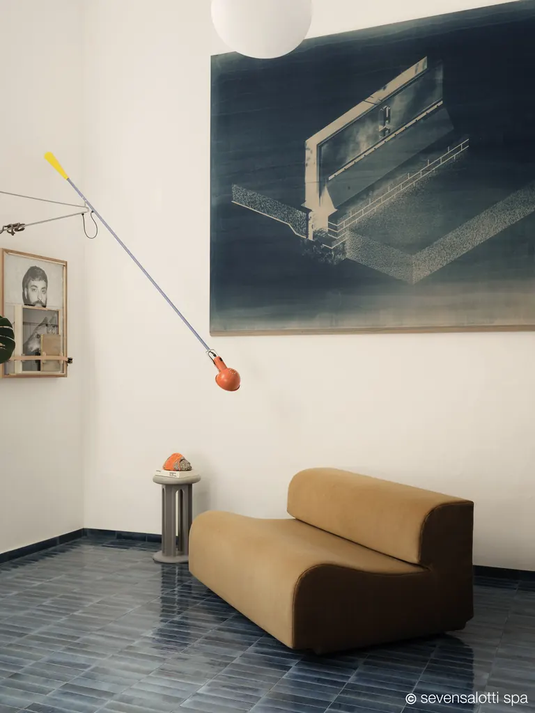 Camel Arflex Bobo sofa on a blue tiled floor, below a large painting