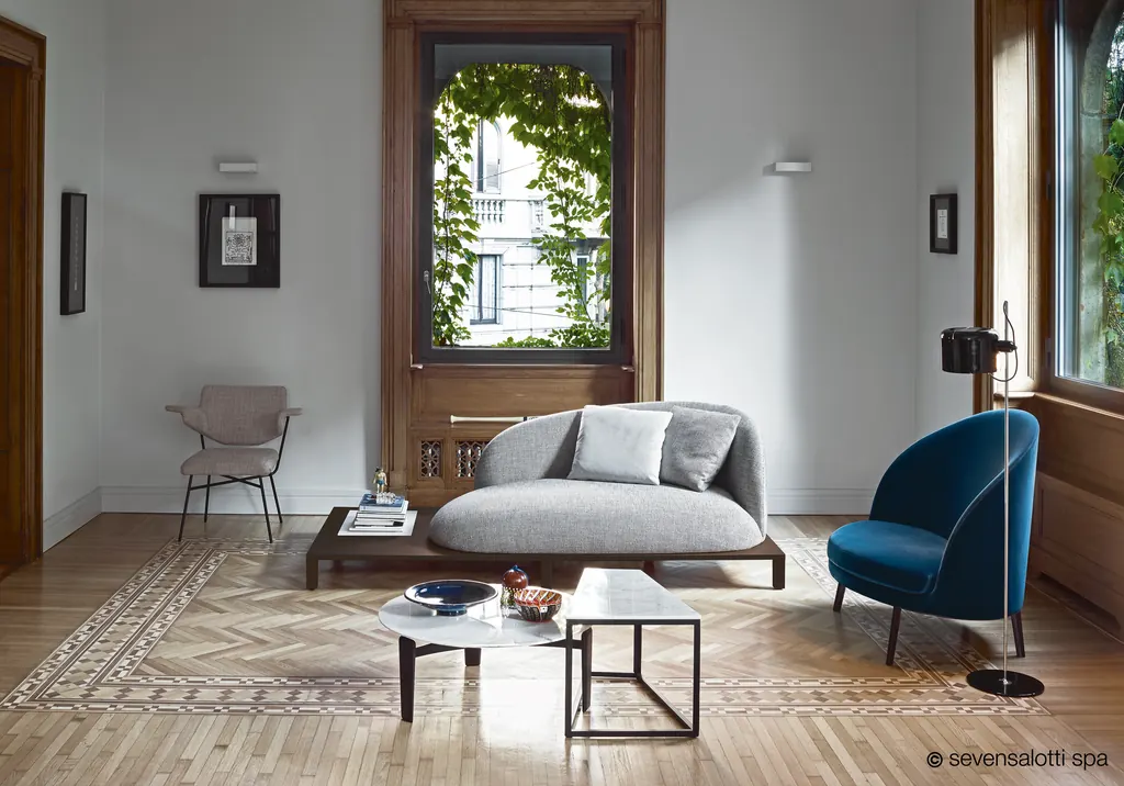 Divano Bonsai Arflex grigio su base in legno in un soggiorno con parquet e finestra sul verde