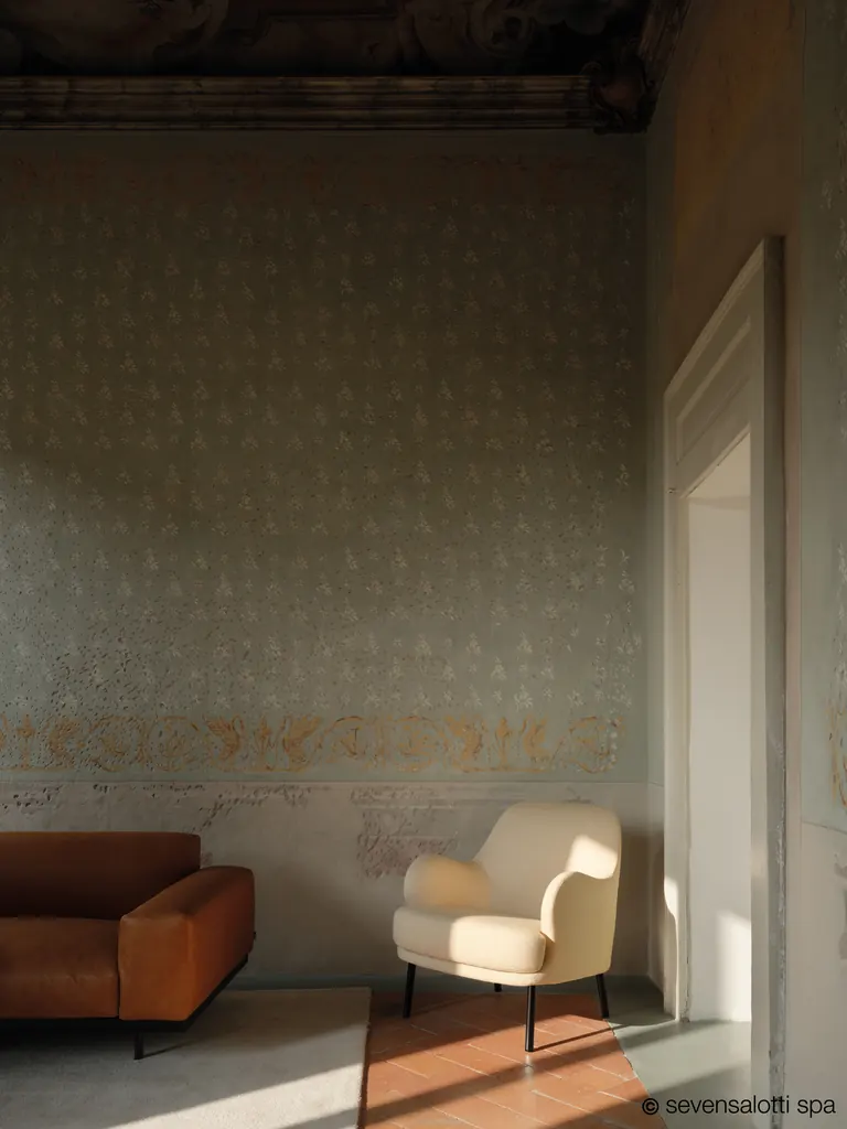 Poltrona Brigitte Arflex color crema in una sala con pareti decorate e un divano color cuoio