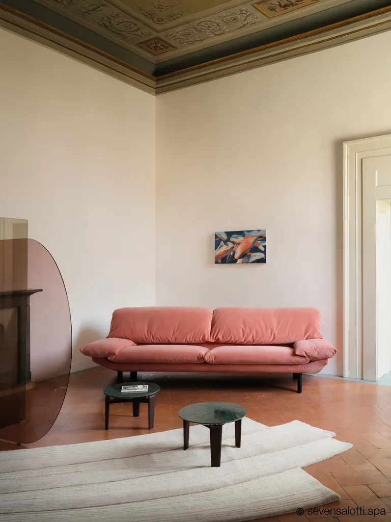 Divano Casablanca Arflex rosa in una sala con soffitto decorato e tavolini rotondi