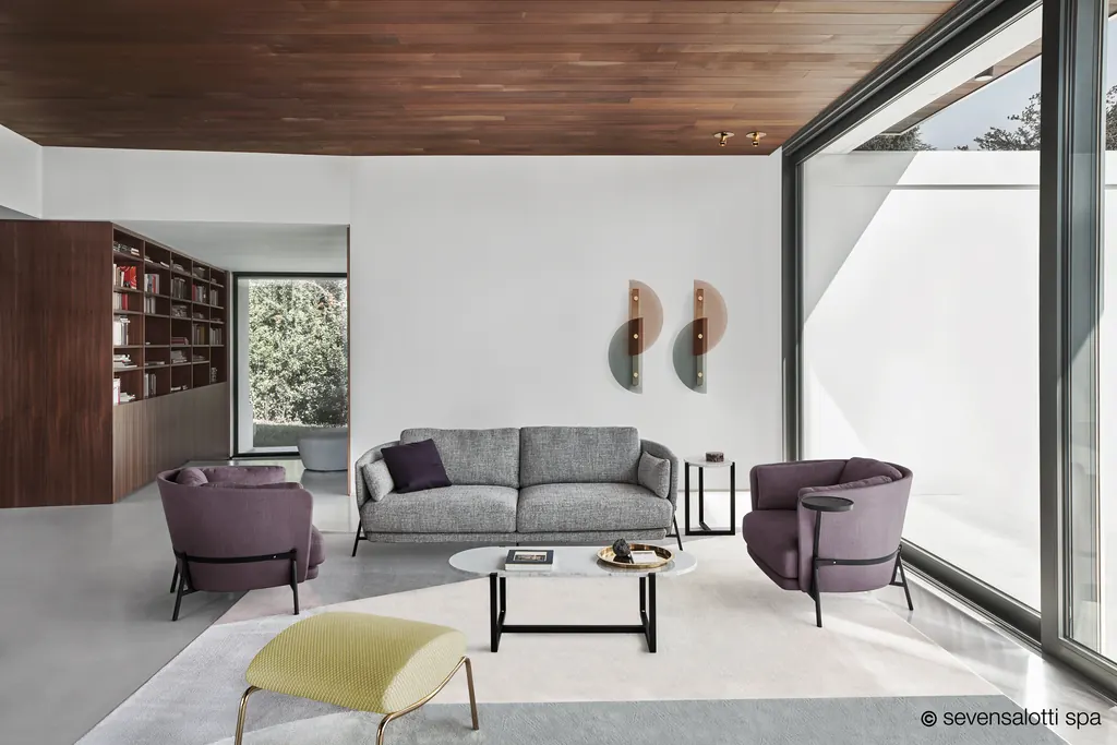 Divano Cradle Arflex grigio e poltrone Cradle color prugna in un soggiorno con grande vetrata