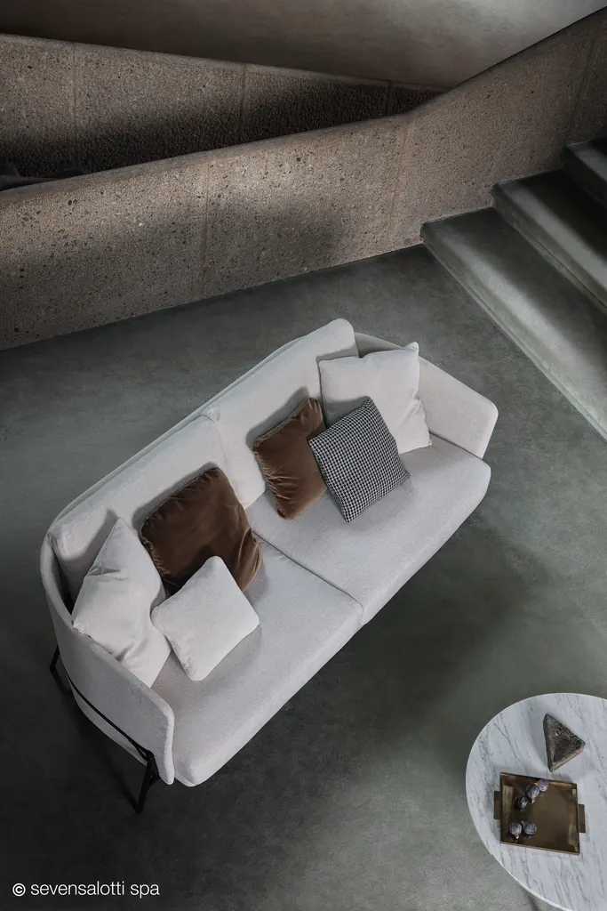 Light grey Arflex Deep Cradle sofa with cushions, seen from above next to a concrete staircase