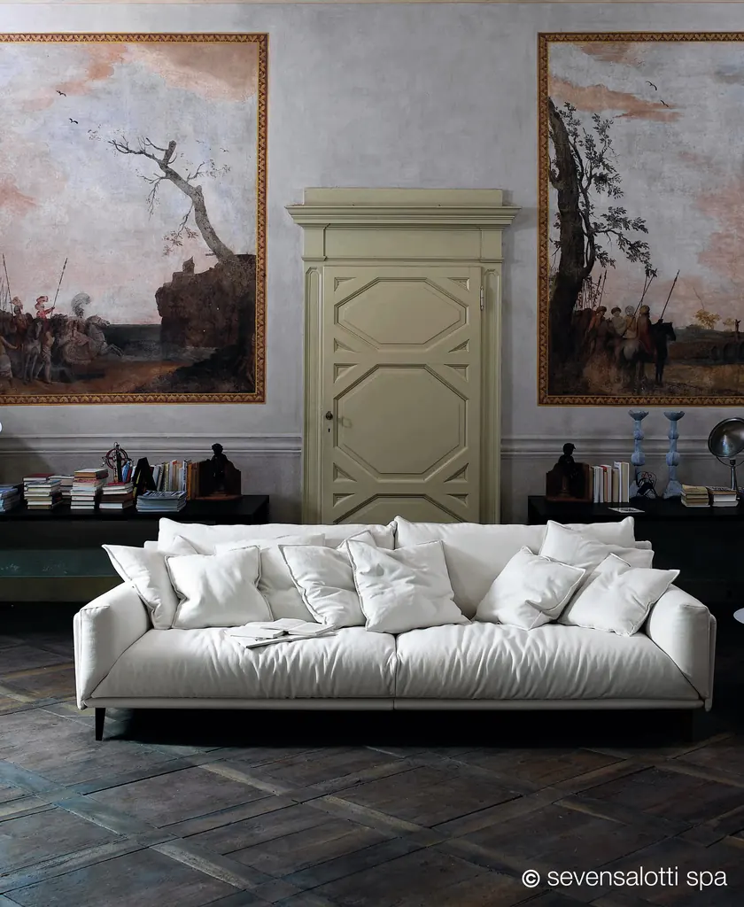 Divano Faubourg Arflex bianco con molti cuscini in una sala con pareti affrescate