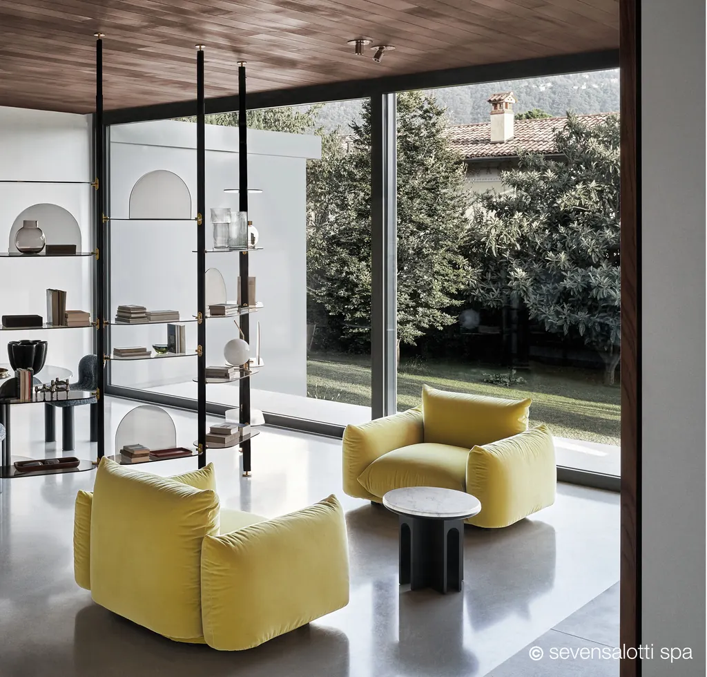 Yellow Marenco Arflex armchairs in front of a window onto the garden