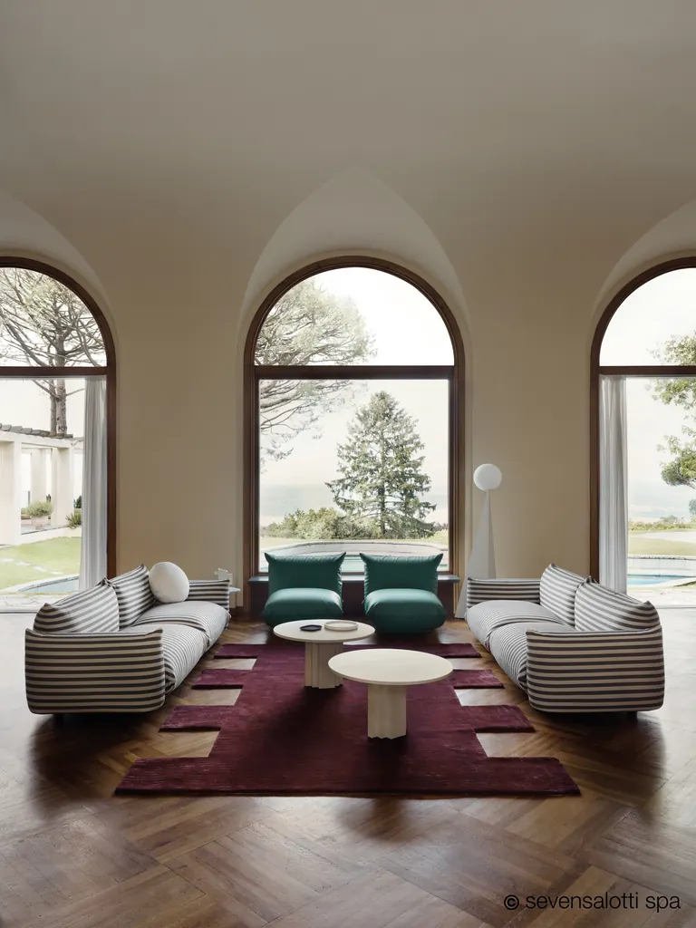 Two black and white striped Marenco Arflex sofas beneath arched windows
