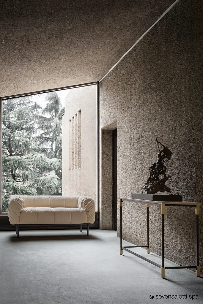 Divano Pecorelle Arflex color crema in una stanza dal soffitto inclinato con grande finestra