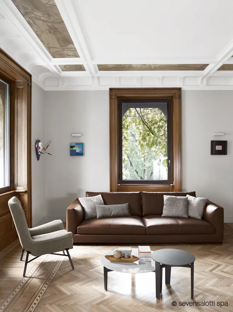 Dark brown Arflex Rendez-Vous sofa in a living room with a decorated ceiling and herringbone parquet