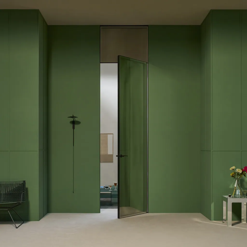 Porta a battente Aladin Swing Plain Duo a tutta altezza in cristallo bronzo, in una parete verde