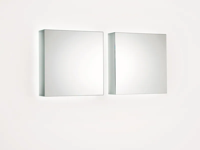 Due specchi quadrati I Massi di Glas Italia affiancati su una parete bianca