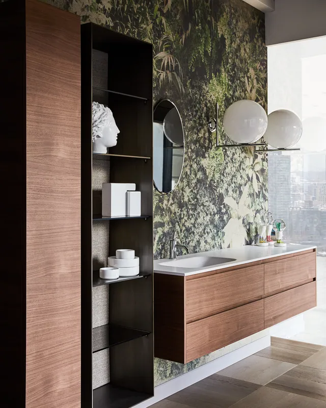 Colonna contenitore in noce e metallo brunito accanto a un mobile lavabo